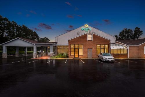 a building with a car parked in a parking lot at Quality Inn in Cornelia