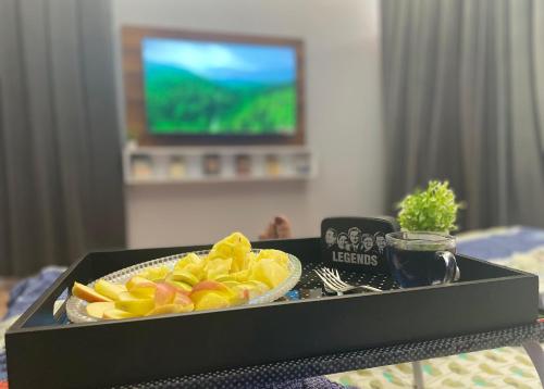 a tray with a plate of fruit on a table at Nawabi SunRise HomeStay in Lucknow
