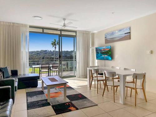 a living room with a table and chairs and a dining room at Unit 31 - Avoca Palms Resort in Avoca Beach