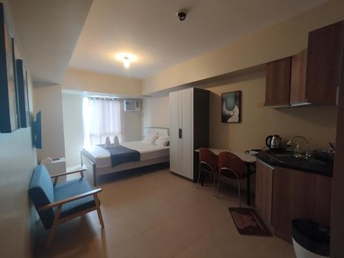 a small room with a bed and a kitchen with a table at Avida Riala Tower one 1402 IT Park in Cebu City