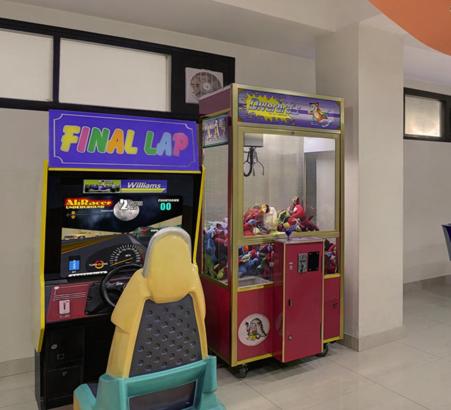 two arcade games in a room with a childs chair at Hotel Combermere in Shimla