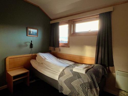 a small bedroom with a bed and a window at Lakselv Hotel in Lakselv