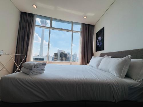 a bedroom with a large bed with a large window at Vortex Suites Klcc 2bedroom & 3bedroom apartment in Kuala Lumpur