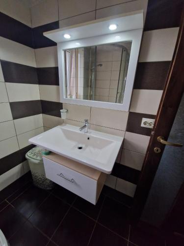 a bathroom with a white sink and a mirror at Apartament 2 camere in Bacău