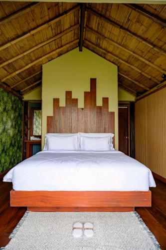 a bedroom with a large bed with a large headboard at Earth Elements Eco Resort in Ban Bu Hua Chang