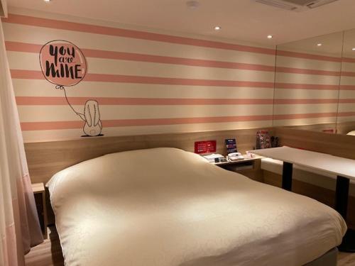 a bedroom with a red and white striped wall at HOTEL Hana - Adult Only in Matsumoto