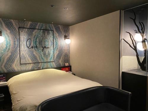 a bedroom with a bed and a sign that says love you at HOTEL Hana - Adult Only in Matsumoto