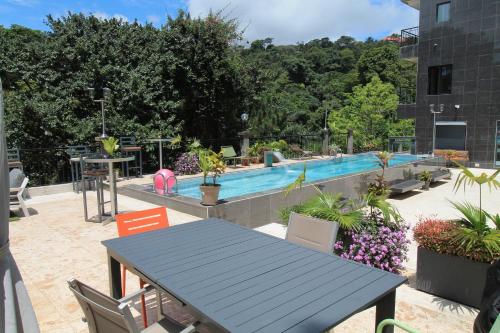 a blue table and chairs next to a swimming pool at Residence MASSOU in Yaoundé