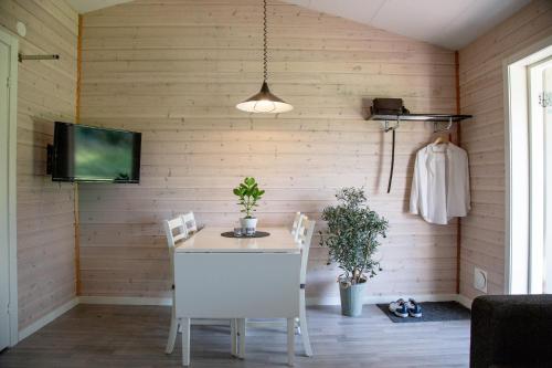 a dining room with a table and chairs and a tv at Alingsås Golfklubb in Alingsås