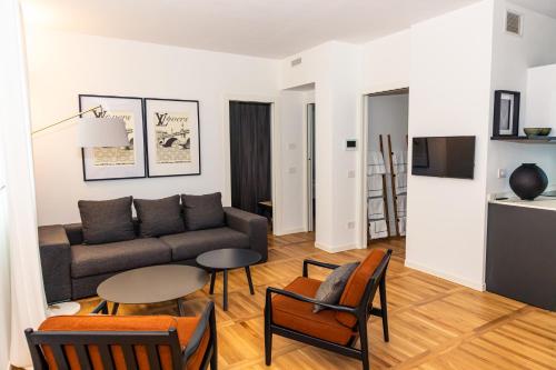 a living room with a couch and a table and chairs at La suite in Piazza in Erbusco