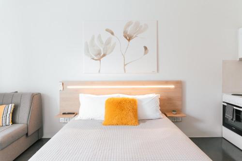 a bed with an orange pillow on top of it at MAGNOLIA SUITES in Nafpaktos