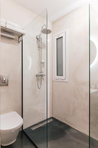 a bathroom with a toilet and a glass shower stall at MAGNOLIA SUITES in Nafpaktos