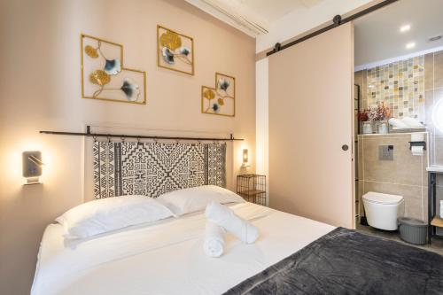 une chambre avec un grand lit blanc et une salle de bain dans l'établissement Adira Marseille Panier 2 étoiles, à Marseille