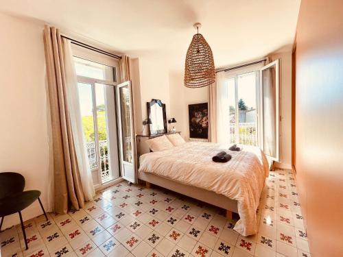 une chambre avec un lit et une grande fenêtre dans l'établissement L'écrin Nimois, à Nîmes