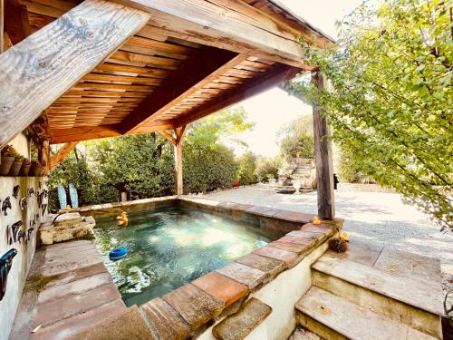 a swimming pool under a wooden pergola at L'écrin Nimois in Nîmes