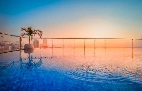 a swimming pool with a palm tree on top of a building at Areca Hotel Nha Trang in Nha Trang