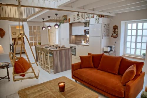a living room with a couch and a kitchen at Gîte le Grenier GRAY in Gray