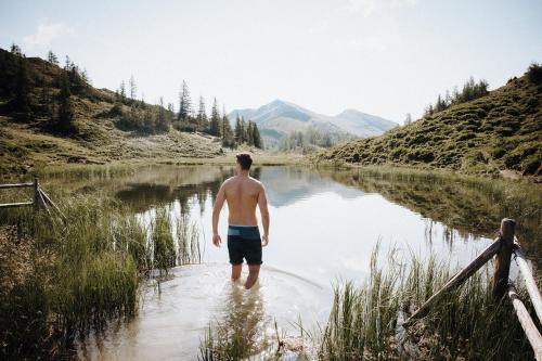 a man standing in the water in a river at Hotel Dorfer in Grossarl