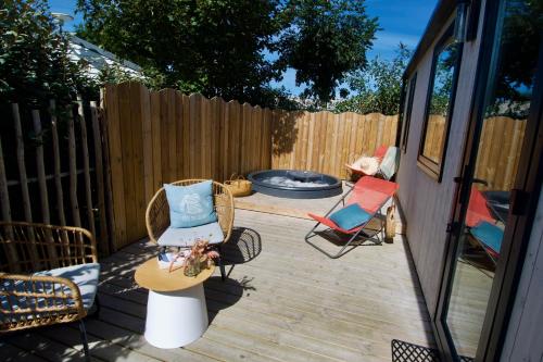 a patio with two chairs and a fire pit at Camping de la côte des légendes in Brignogan-Plages