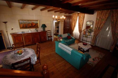 un salon avec un canapé bleu et une table dans l'établissement Chez Germaine, à Mesnac