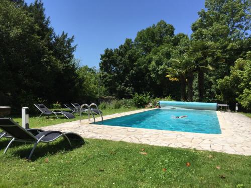 une piscine avec des chaises et une personne qui s'y couche dans l'établissement Chez Germaine, à Mesnac