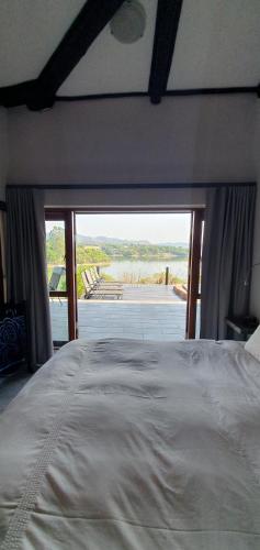 a bedroom with a bed with a view of a river at DaGama Dam - White River - Kestrel - House 21 in White River