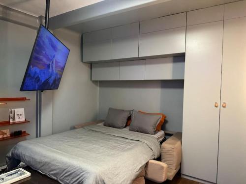 une chambre avec un lit et une télévision au mur dans l'établissement Charming Paris Studio Apartment, à Paris