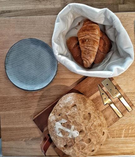 a table with two loaves of bread and a basket at Fürstenhof Sassnitz - PANORAMA103 in Sassnitz