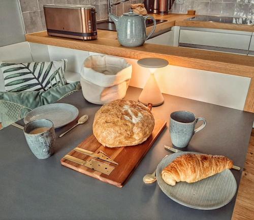 a table with a cutting board with a loaf of bread at Fürstenhof Sassnitz - PANORAMA103 in Sassnitz
