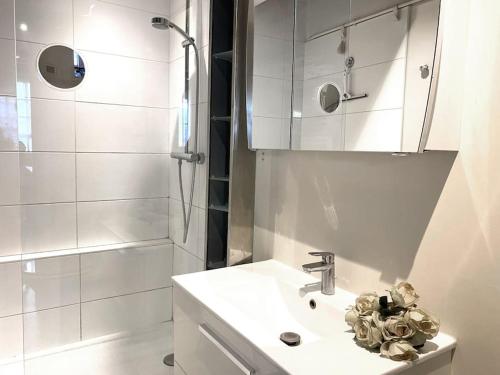 une salle de bain blanche avec un lavabo et une douche dans l'établissement Nid douillet au cœur de Paris, à Paris