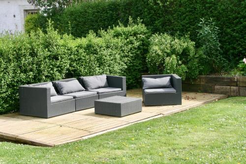 two couches sitting on a wooden deck in a yard at Gertrude&Friends in Herbais