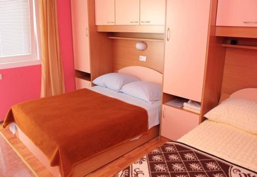 Un dormitorio pequeño con dos camas en una habitación. en Apartments Vinko, en Vir