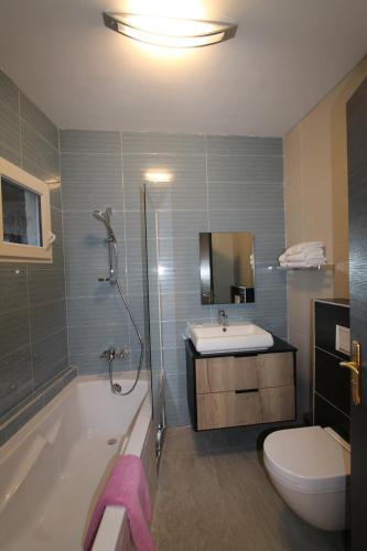 a bathroom with a tub and a sink and a toilet at Residence MASSOU in Yaoundé