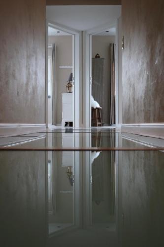 an empty living room with a reflection in the floor at Gertrude&Friends in Herbais