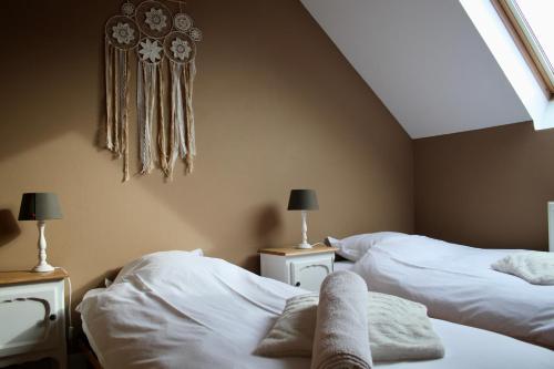 a bedroom with two white beds and a window at Gertrude&Friends in Herbais