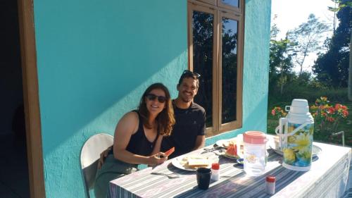 a man and a woman sitting at a table at Hobbit Hill in Ruteng