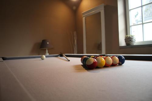 a pool table with cue balls on top of it at Gertrude&Friends in Herbais