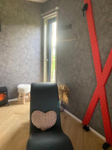 a room with a black chair with a heart on it at Le love van in Tronquoy
