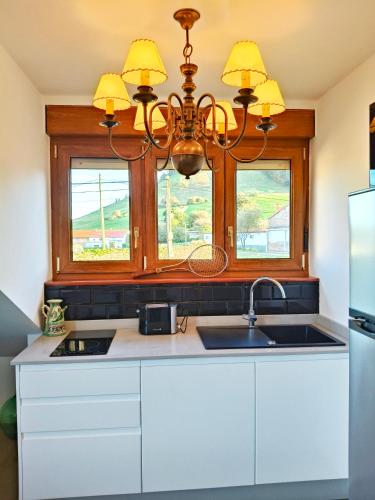 a kitchen with a sink and a chandelier at La casa de las palas Tok-pok in Mogro