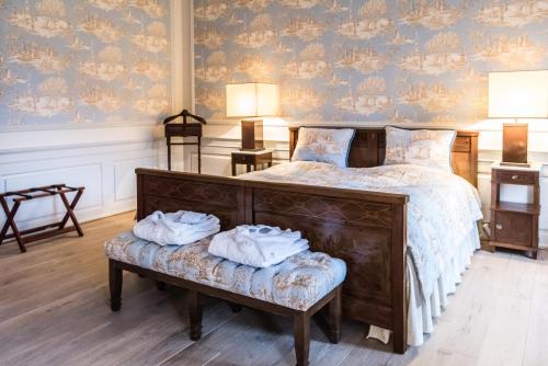 a bedroom with a bed with two towels on a bench at Skjoldenæsholm Slot in Jystrup