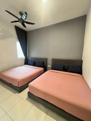 two beds sitting next to each other in a bedroom at Lily Brava 5 in Tanah Rata