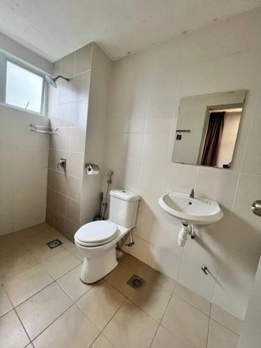 a white bathroom with a toilet and a sink at Lily Brava 5 in Tanah Rata