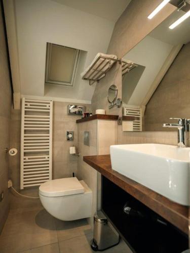 une salle de bain avec un lavabo blanc et des toilettes dans l'établissement BRIT HOTEL PRIVILEGE LISIEUX - La Villa des Arts, à Lisieux
