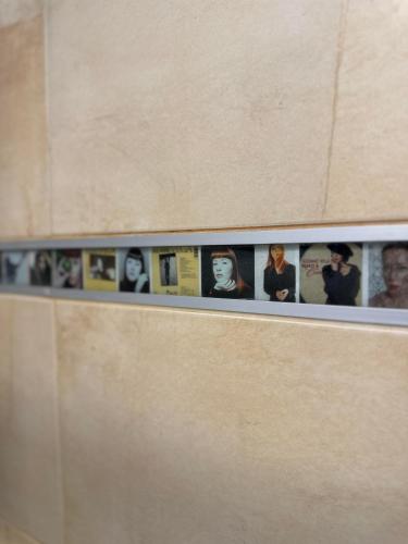 a row of pictures on the top of a wall at Hotel Muza in Košice