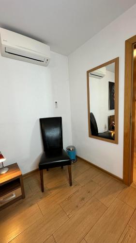 a black chair in a room with a mirror at Hotel Muza in Košice