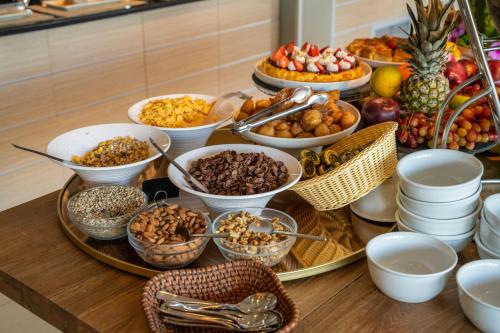um buffet de comida numa mesa com tigelas de comida em San Nicolas Resort Hotel em Mikros Gialos