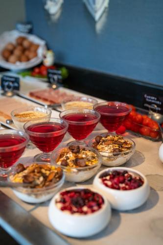 um buffet com taças de comida e taças de vinho em San Nicolas Resort Hotel em Mikros Gialos