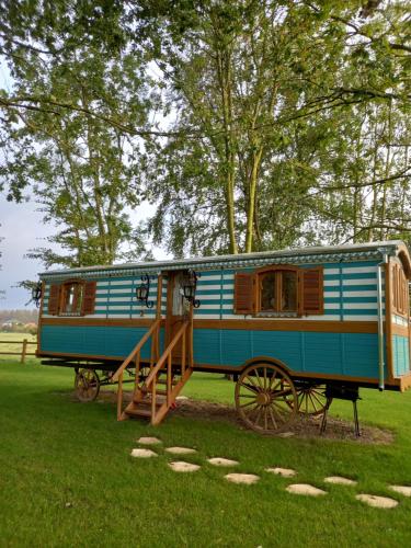 a blue train car on display in a field at Roulotte de charme in Villers-sur-Authie