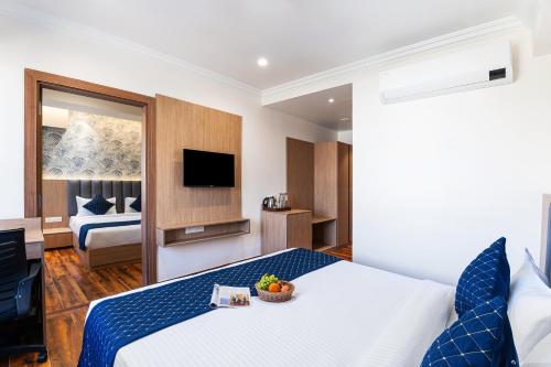 a hotel room with a bed and a television at Sinclairs Udaipur in Udaipur