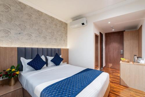 a bedroom with a large bed with blue pillows at Sinclairs Udaipur in Udaipur